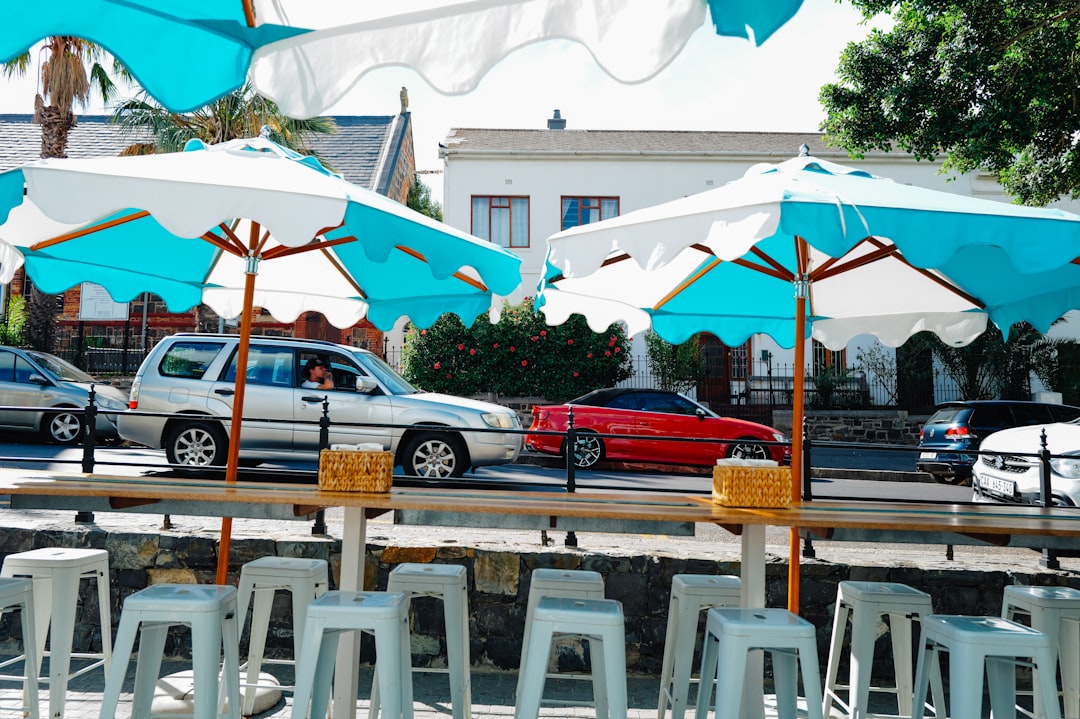 an outdoor cafe patio with colorful umbrellas and flowers