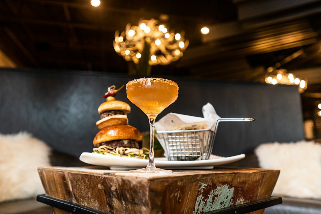 artisanal cocktails and small plates on a rustic wooden table in a dimly lit restaurant