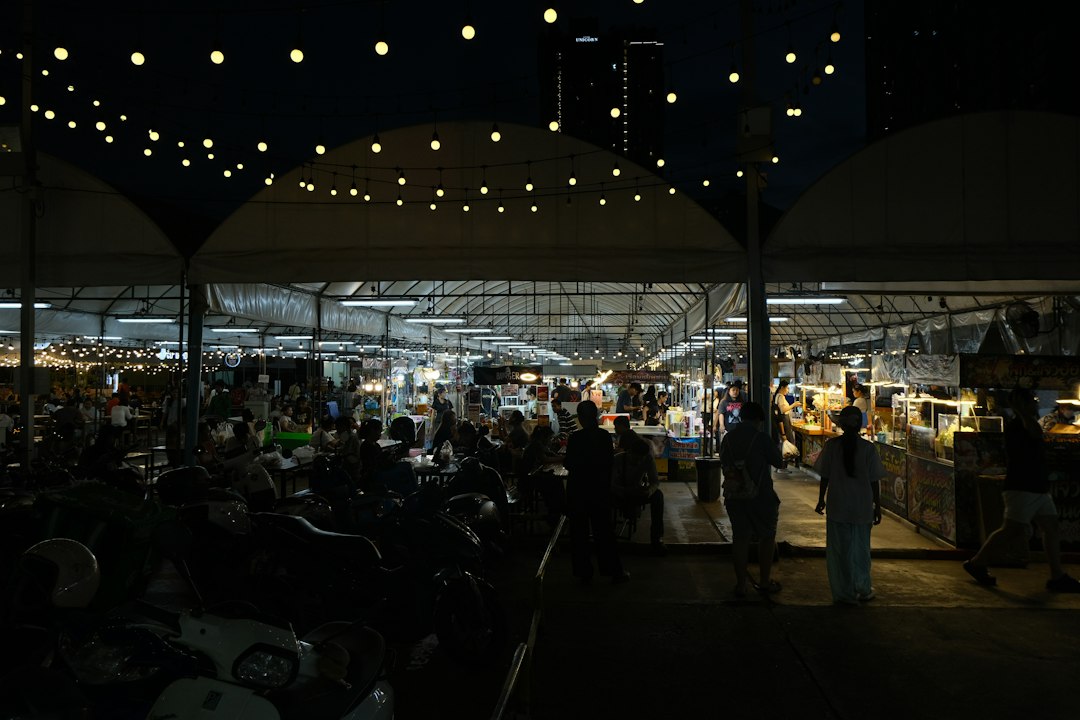 outdoor food park with string lights and people eating at picnic tables