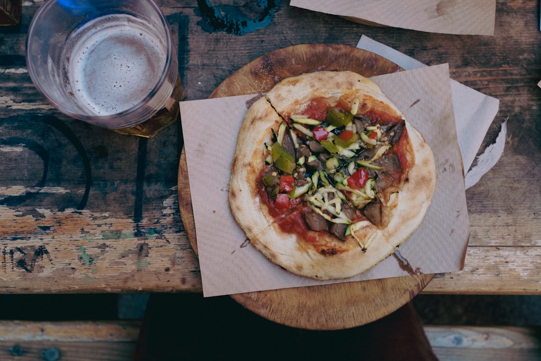 overhead shot of a vibrant, delicious-looking pizza on a rustic wooden table