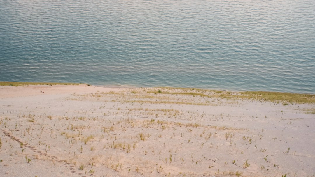 a person kayaking on a calm coastal dune lake at sunrise
