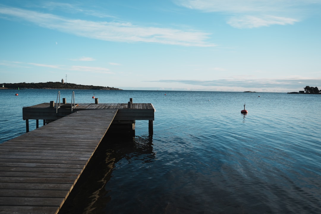 a small seafood shack on a wooden pier over calm blue water