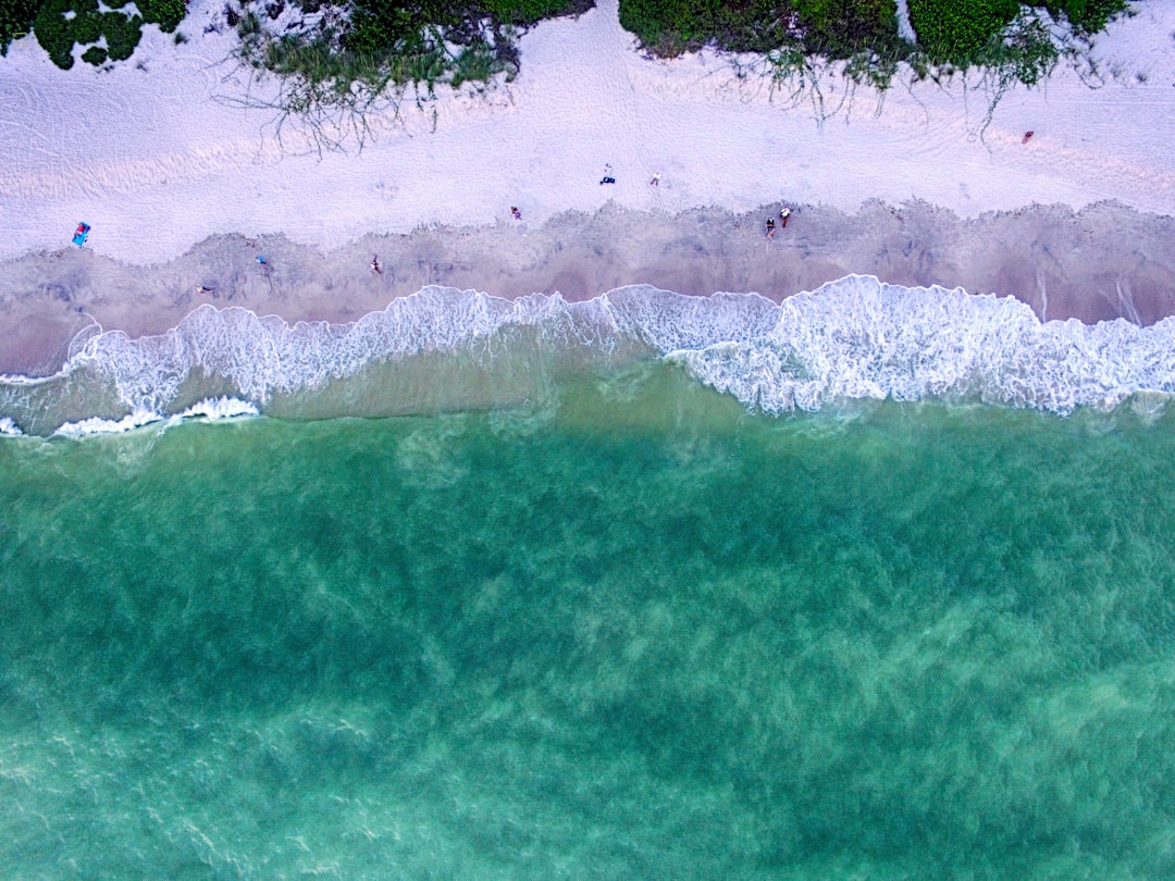 aerial view of a pristine white sand beach with turquoise water in Florida