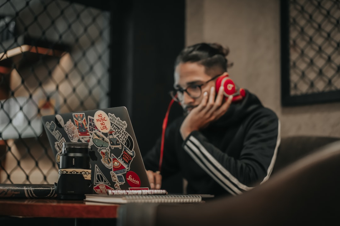 frustrated person on the phone looking at a laptop and calendar