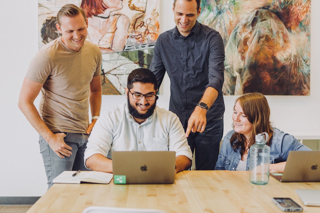 diverse group of friends planning a trip around a laptop