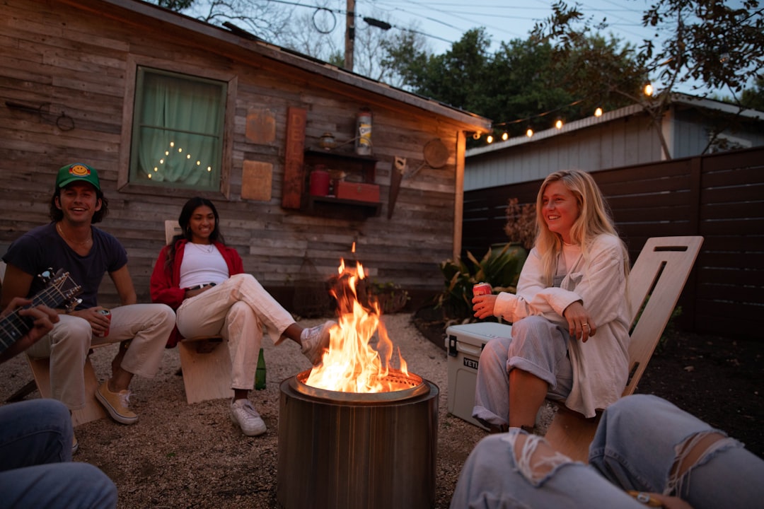 family roasting marshmallows over a backyard fire pit at dusk