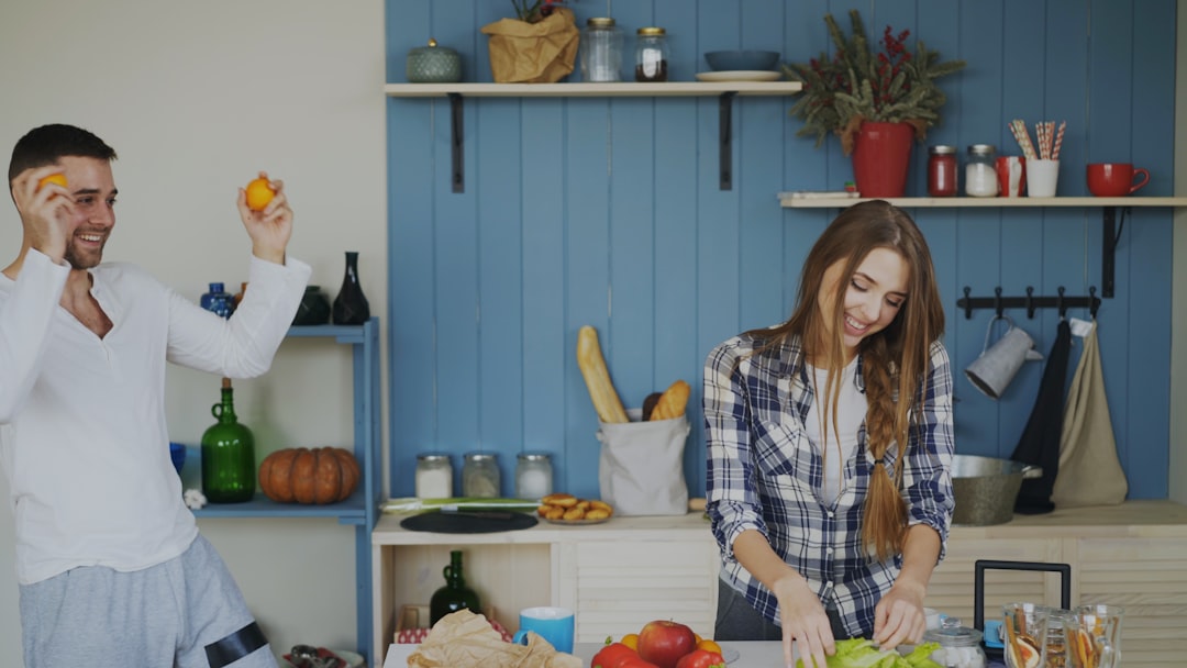friends unpacking groceries and laughing in a modern kitchen