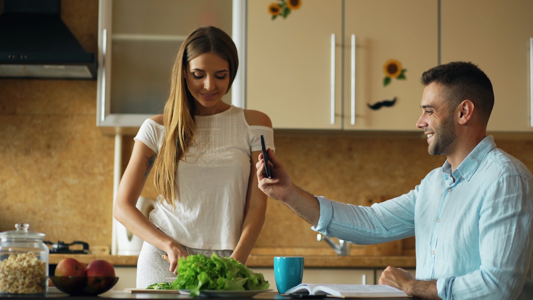 large group of friends cooking together in a modern kitchen, laughing
